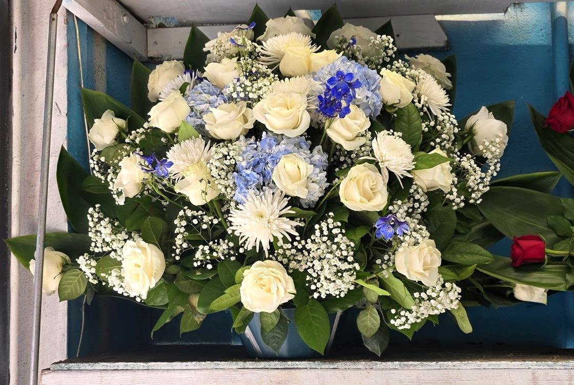 White roses with blue hydrangea β a bright birthday arrangement