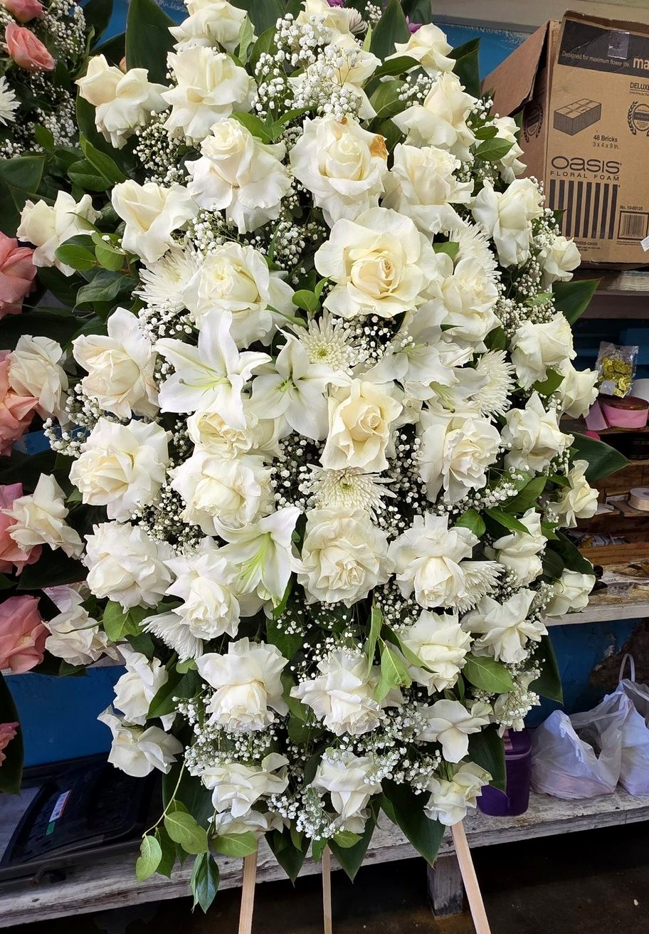 White standing sympathy spray of roses and lilies